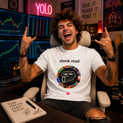 Young YOLO-style trader with messy hair in a modern home trading room wearing a white stonk.mad nano.narrative graphic tee surrounded by stock charts, neon lights, and an electric guitar.